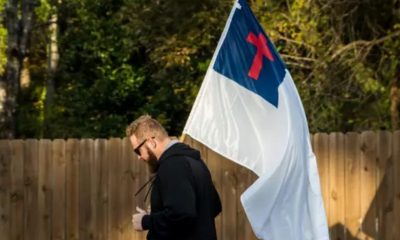 Homem carrega bandeira cristã