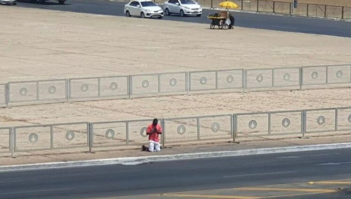 Momento em que o homem ora em frente ao Palácio do Planalto