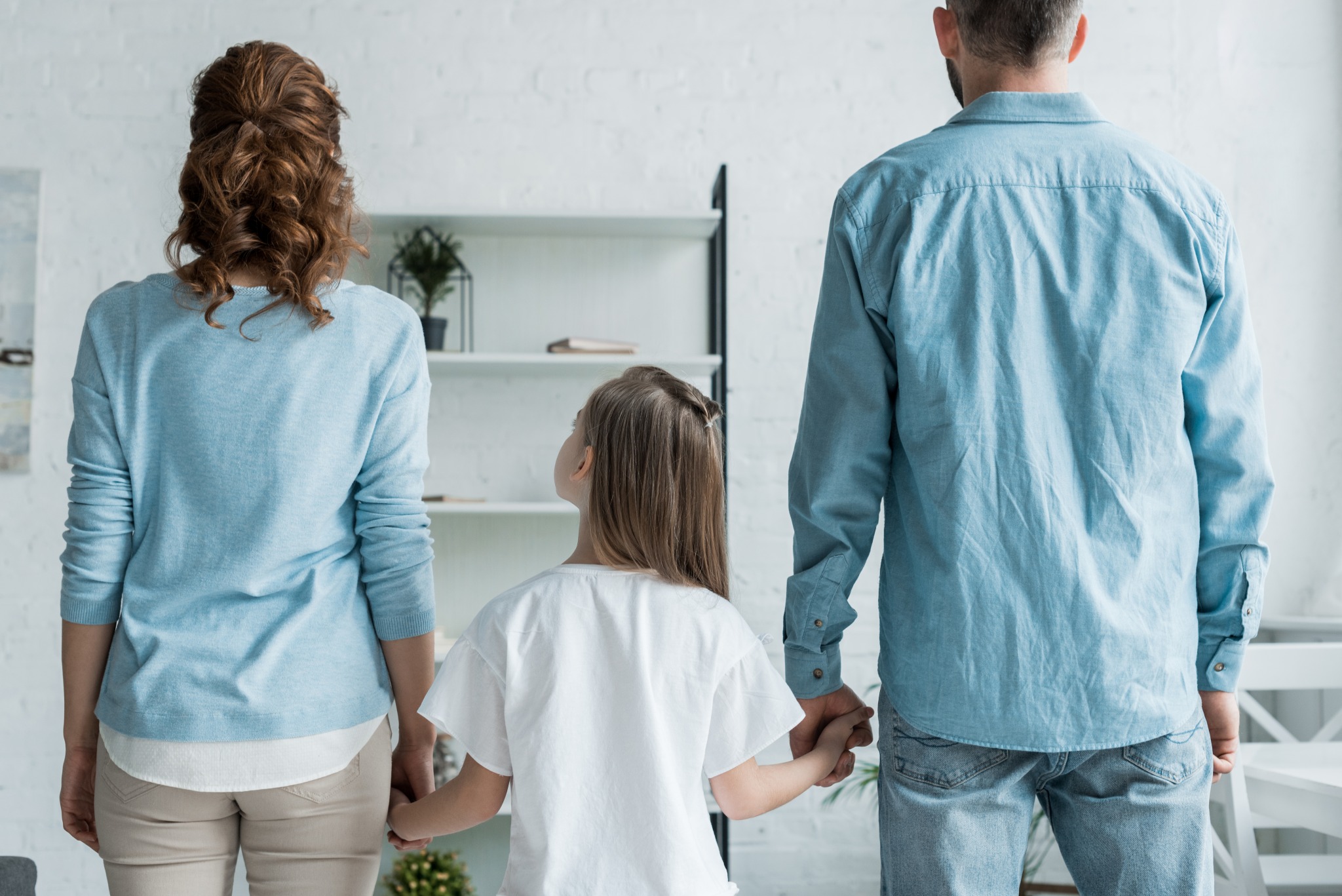 pai e mãe de mãos dadas com a filha