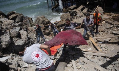 Palestinos tiram um corpo de escombros em Gaza