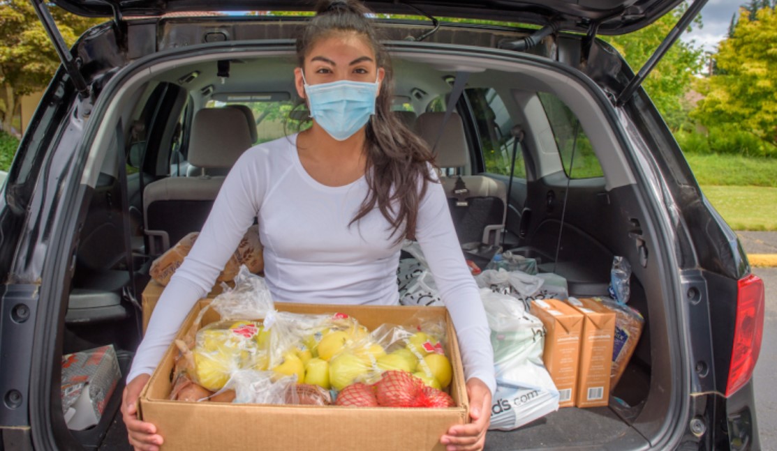 Jovem com alimentos para doação